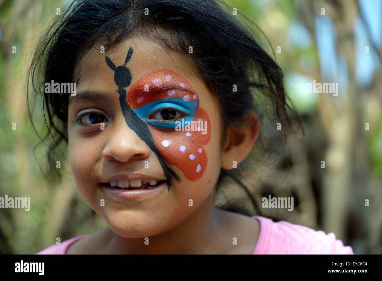 Girl with butterfly makeup, at a children's festival, peace initiative of the police and the Catholic Church in the slum of Stock Photo