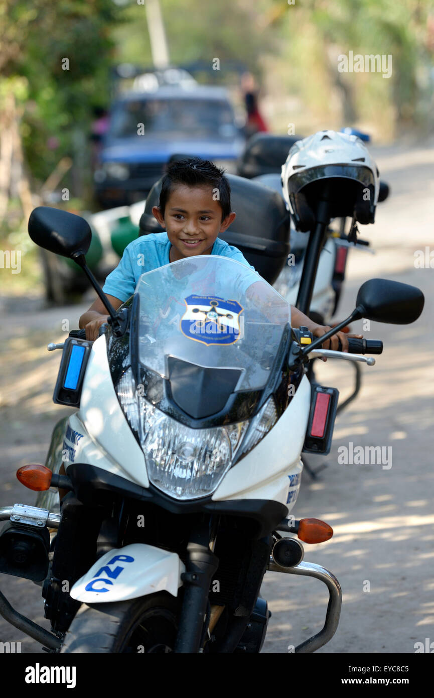 Boy on a police motorcycle at a peace initiative by the police and the Catholic Church in the slum of Colonia Monsenor Romero Stock Photo