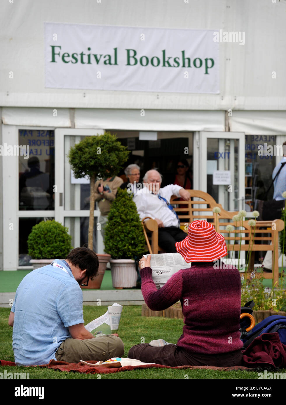 Book lovers read newspapers at the Hay Literature Festival in Hay-on-Wye, UK Stock Photo