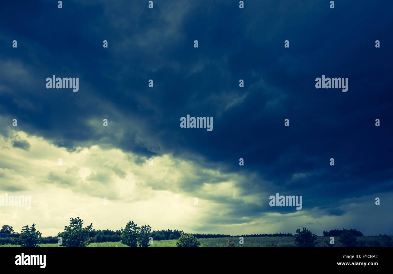 Vintage photo of dark stormy clouds over corn field at summer ...