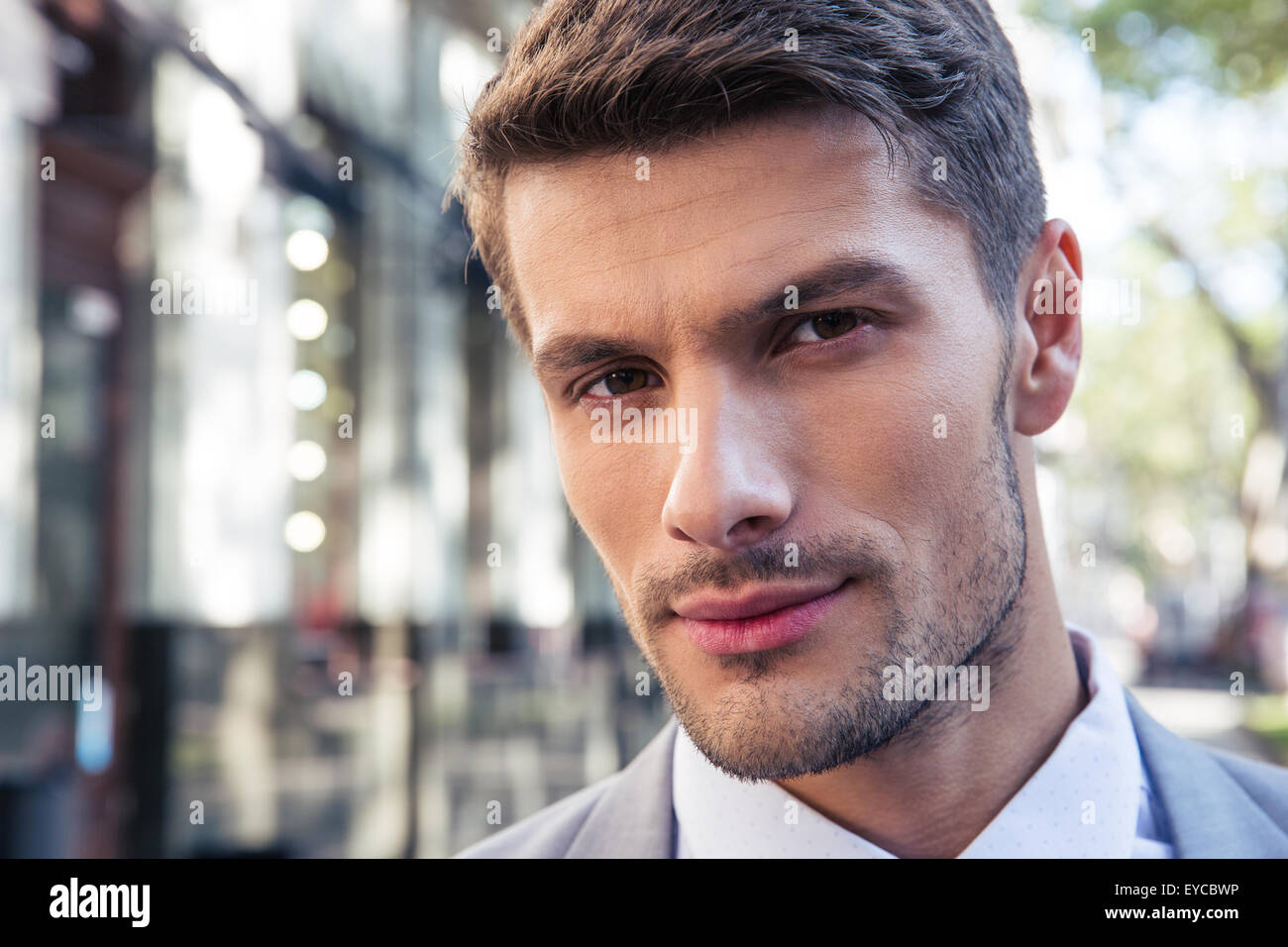 Closeup portrait of a handsome businessman outdoors looking at camera ...
