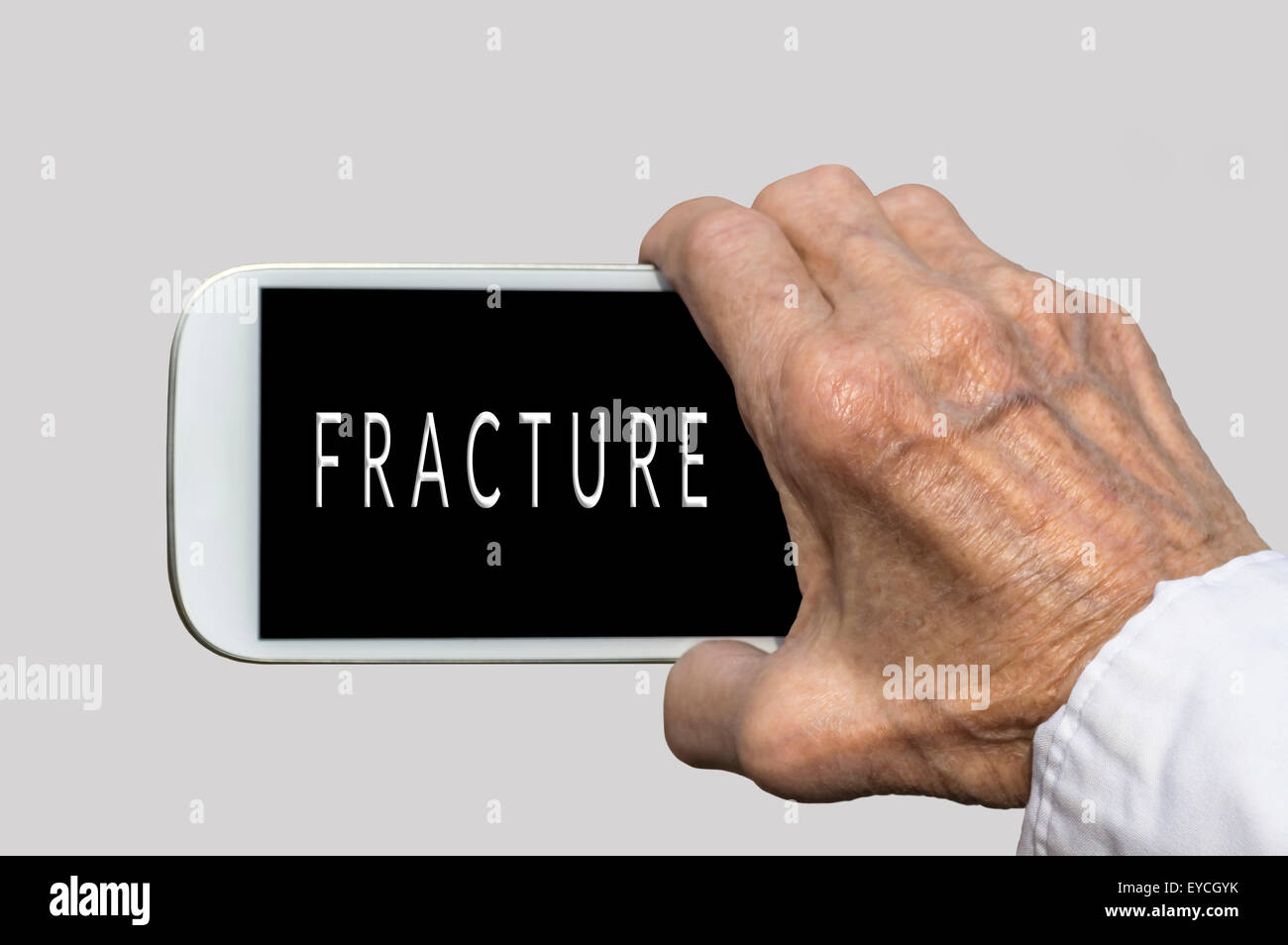 Smart phone in old hand with FRACTURE text on screen. Selective focus Stock Photo