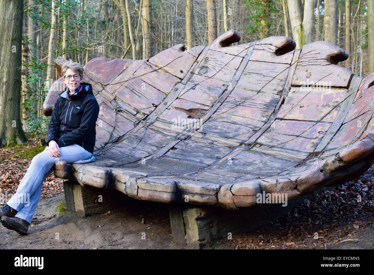 woman-sitting-on-oak-leaf-sculpture-in-chopwell-woods-gateshead-stock