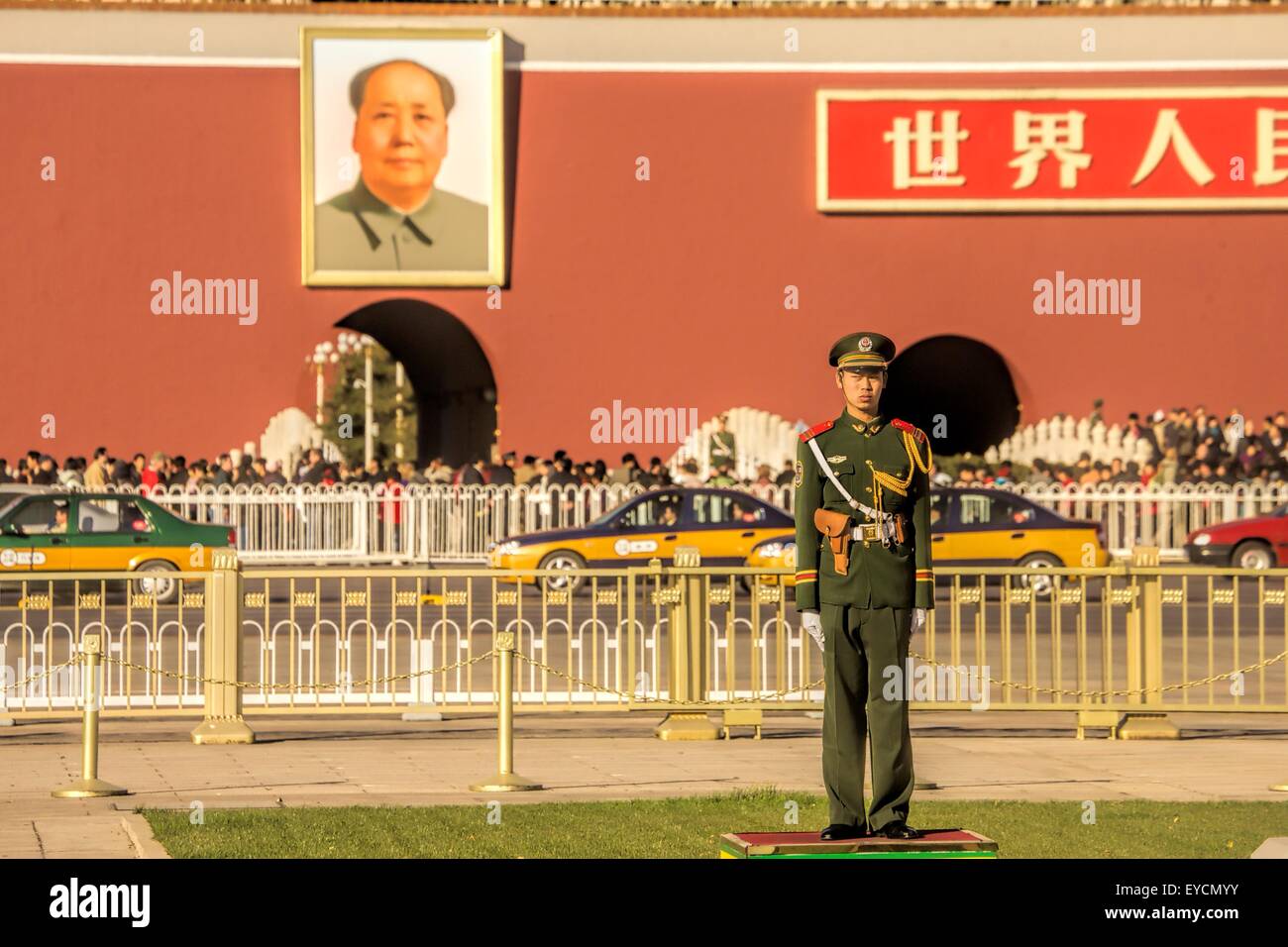 A guard stands watch in front of a portrait of Chairman Mao hanging from the wall of the Forbidden City in Tienanmen Square Stock Photo