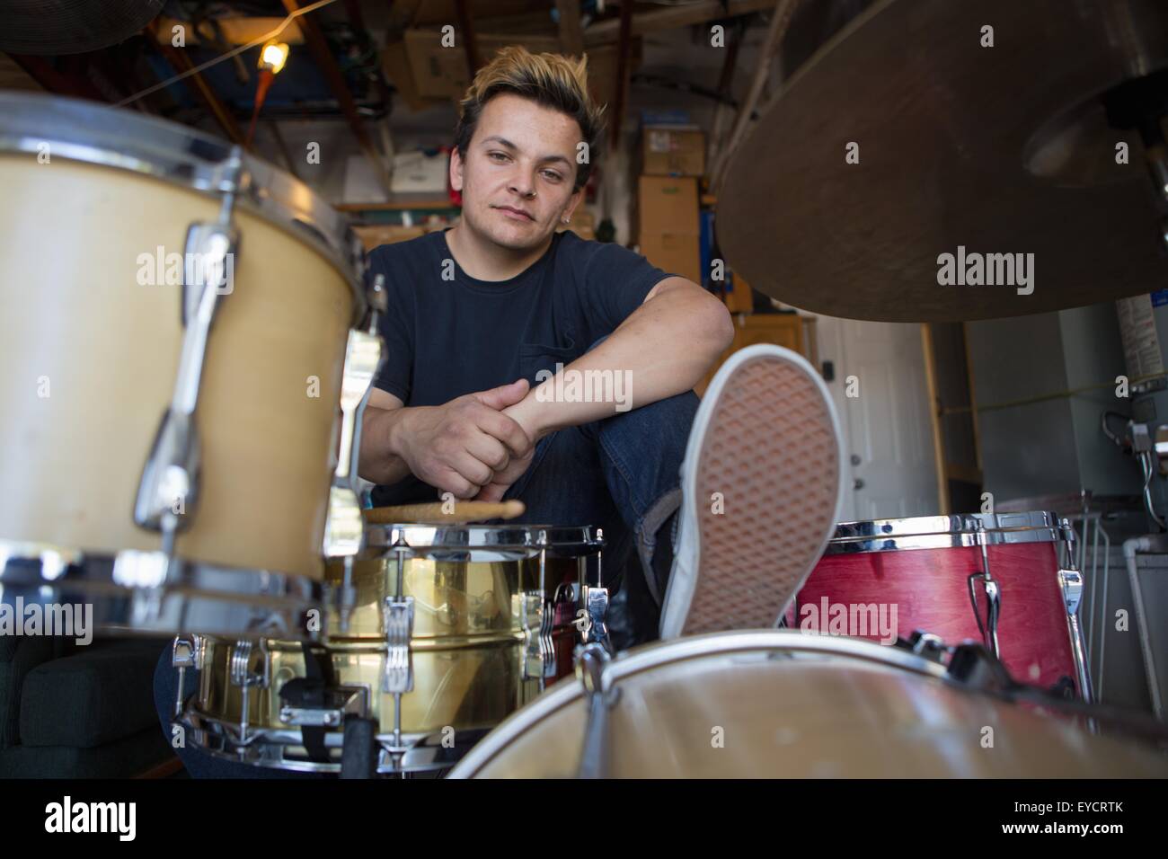 Portrait of young male drummer in basement Stock Photo