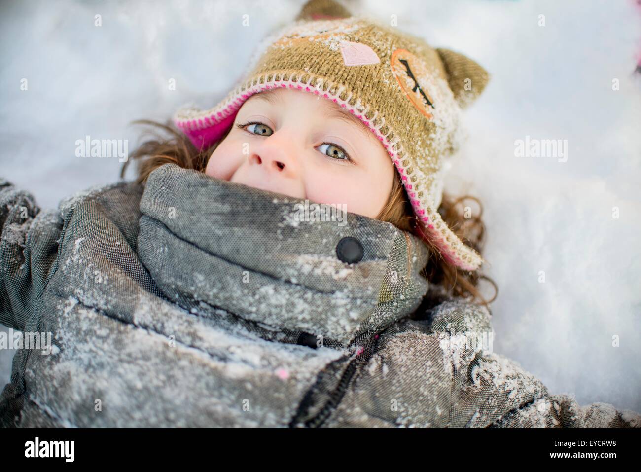 Girl lying on snow Stock Photo