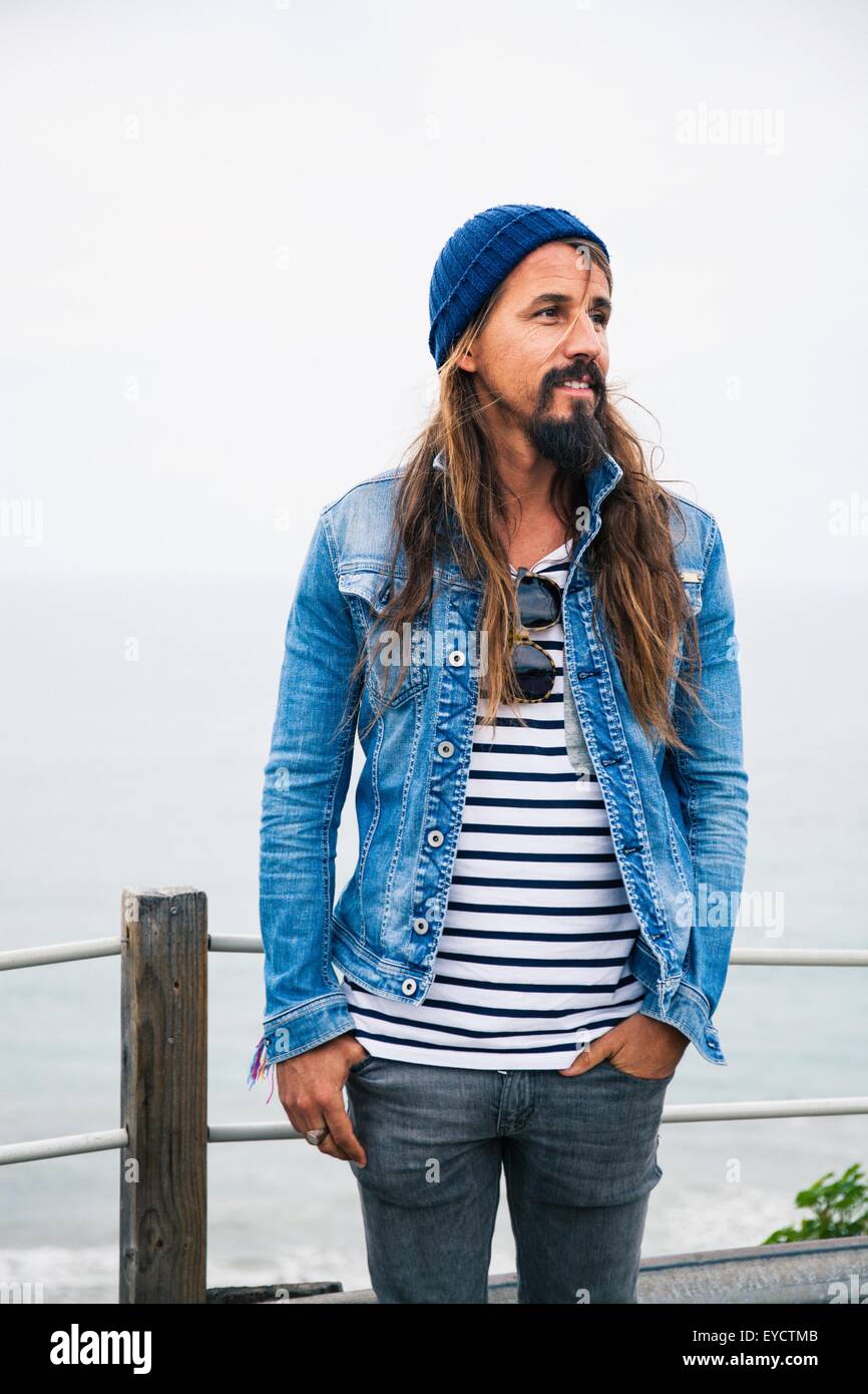 Mid adult man wearing denim jacket and striped top Stock Photo - Alamy
