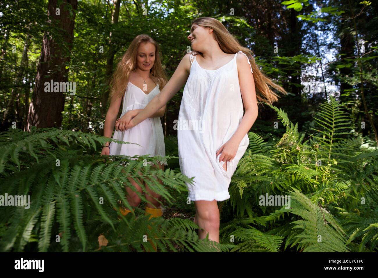 Two teenage girls wandering through forest Stock Photo