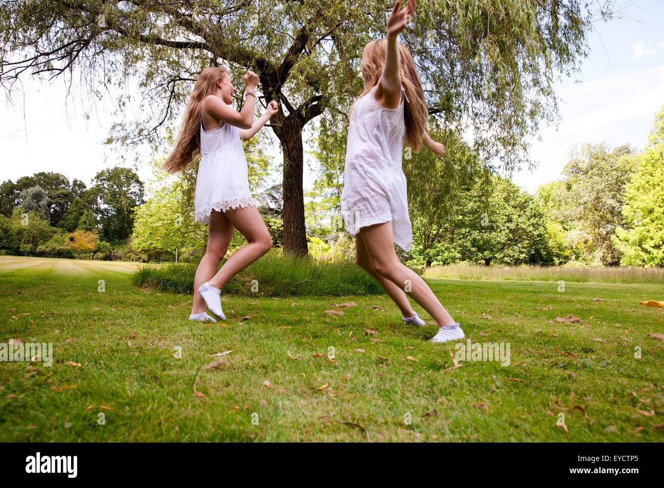 Two teenage girls dancing in field, low angle view Stock Photo