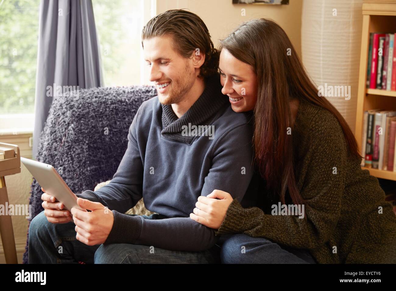 Young couple browsing digital tablet in living room Stock Photo