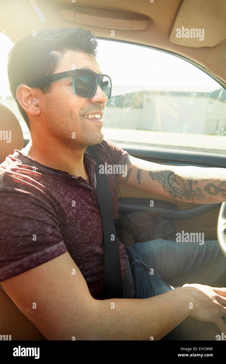 Smiling young man driving car Stock Photo