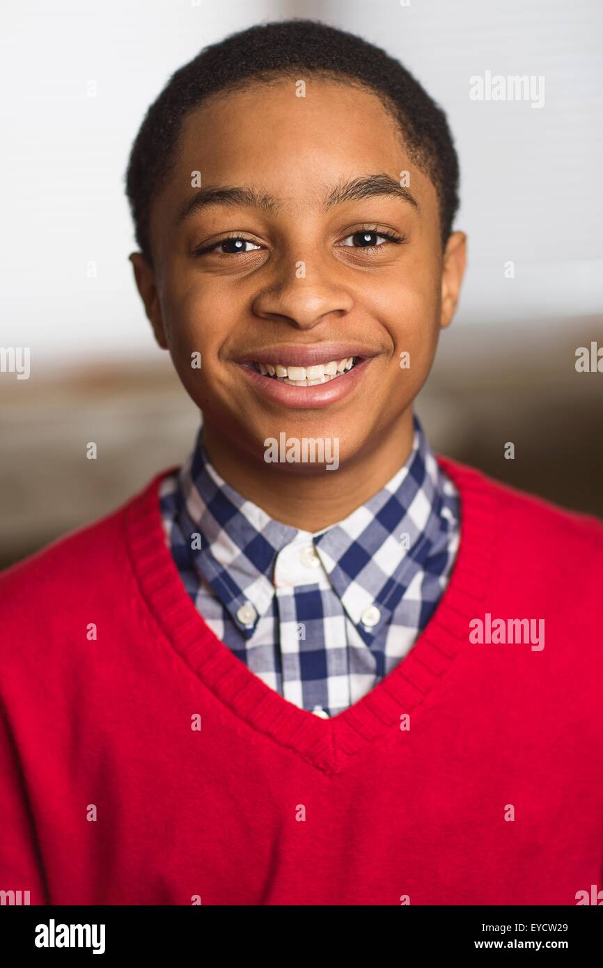 Portrait of smiling teenage boy wearing red sweater Stock Photo