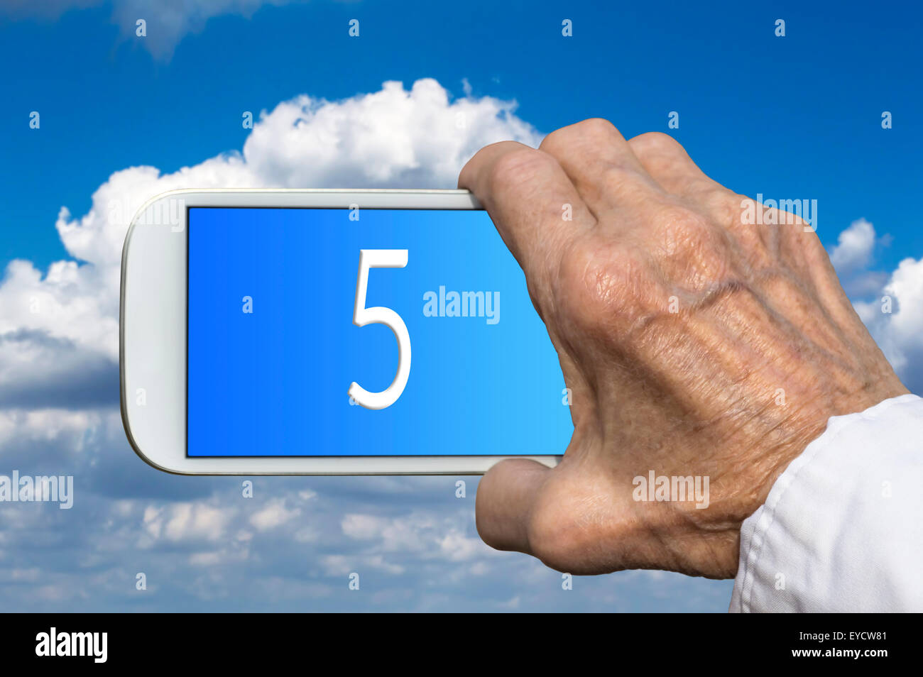 Smart phone in old hand with number FIVE on screen. Selective focus Stock Photo