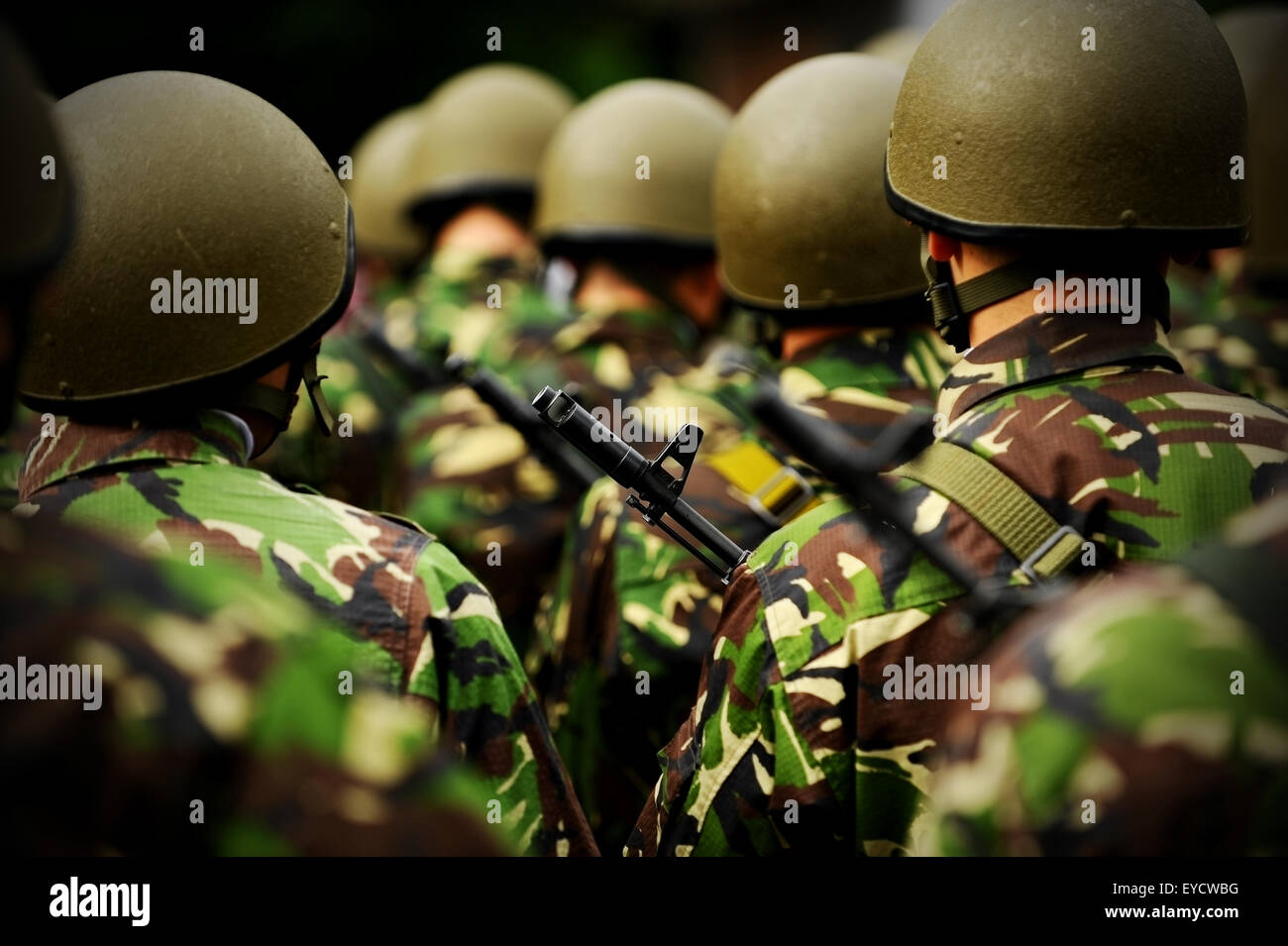 Rifle detail shot in a group of unrecognizable soldiers in camouflage uniform Stock Photo