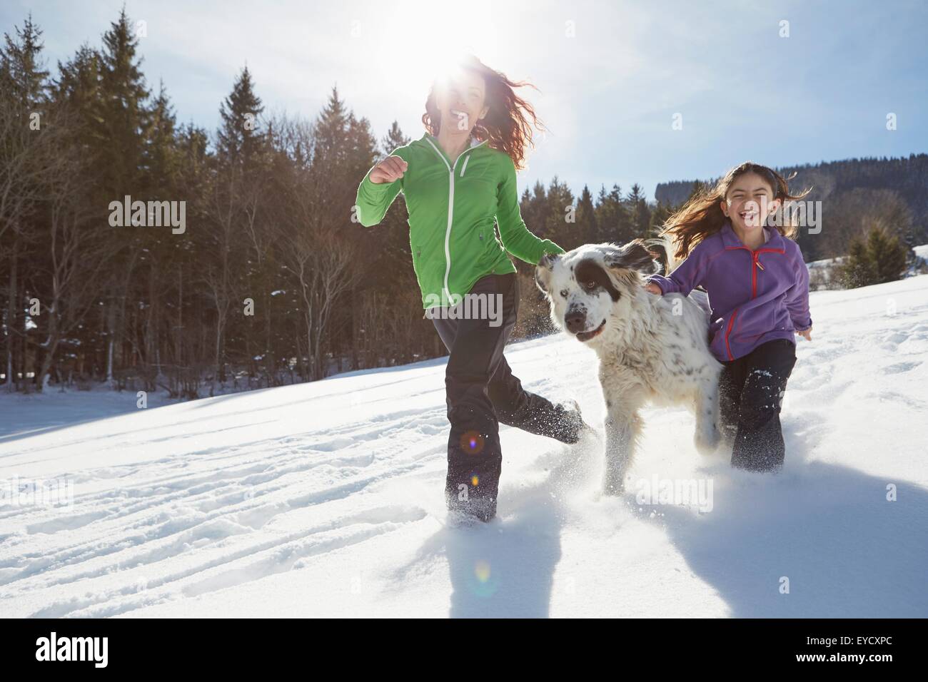 Mother and daughter running with their pet dog Stock Photo