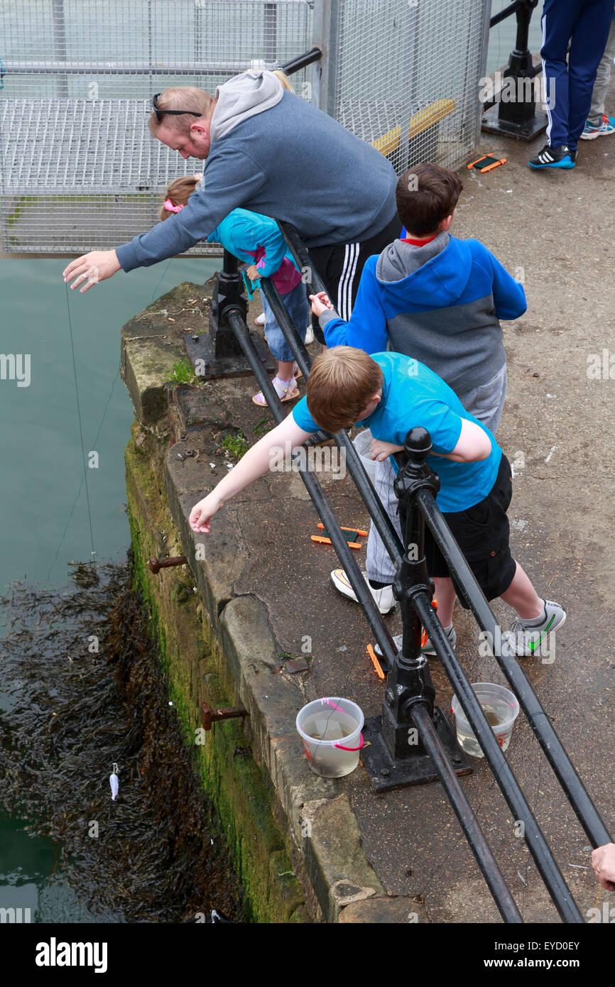 Fishing for crabs from the harbour at Whitby, Yorkshire Stock Photo