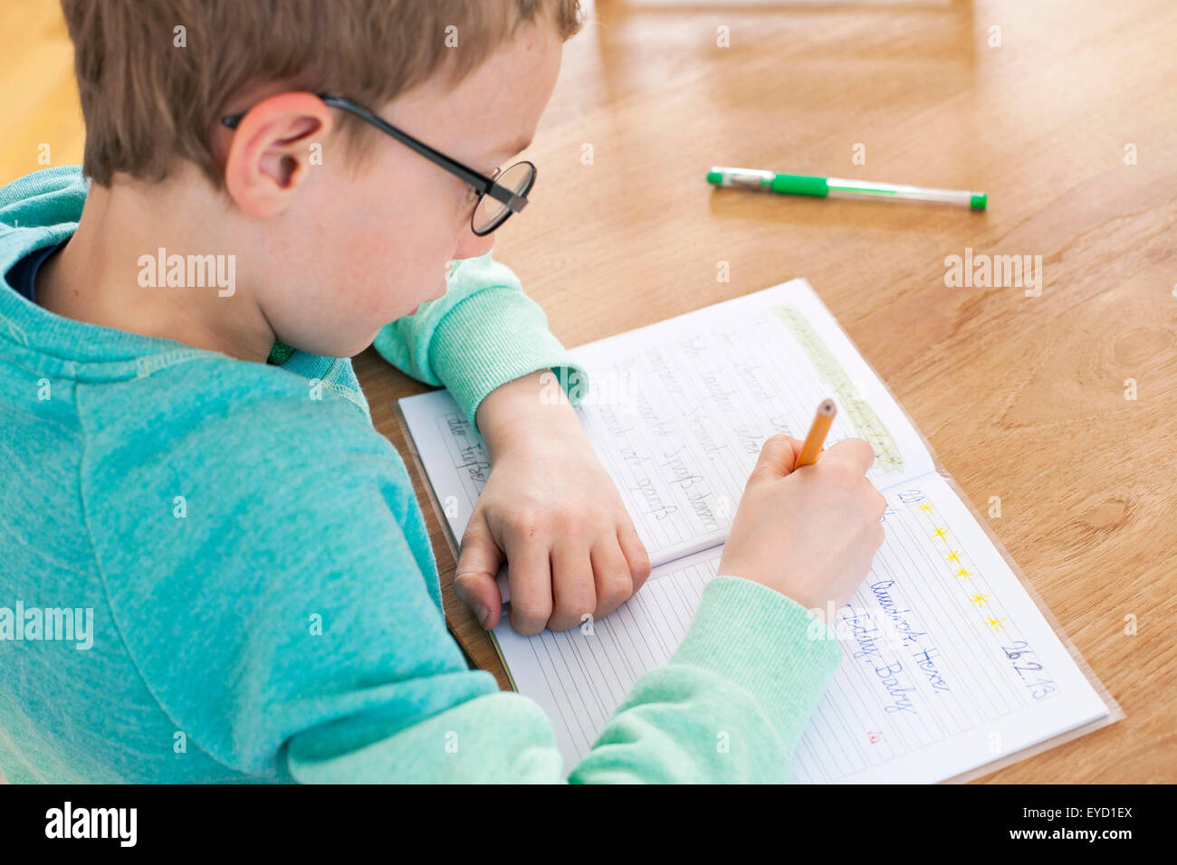 Boy writing in exercise book Stock Photo