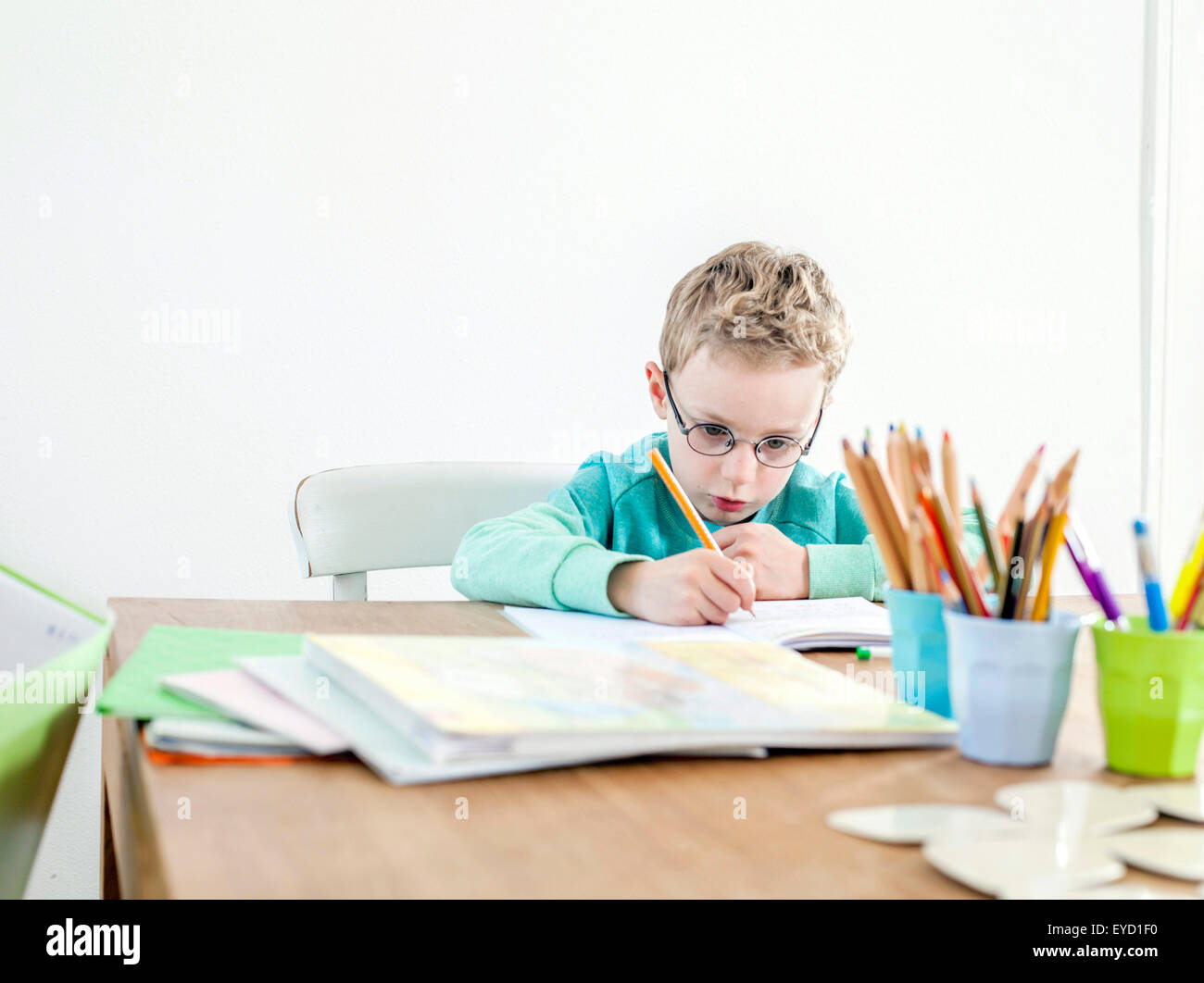 Boy writing in exercise book Stock Photo