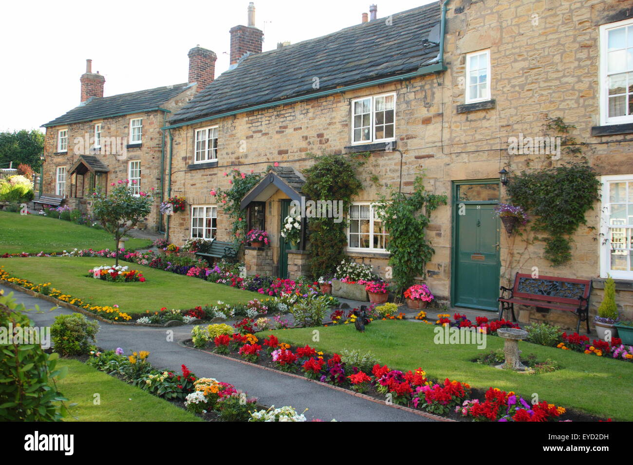 Traditional British stone-built cottages with pristine garden borders in an English estate village, South Yorkshire, England UK Stock Photo