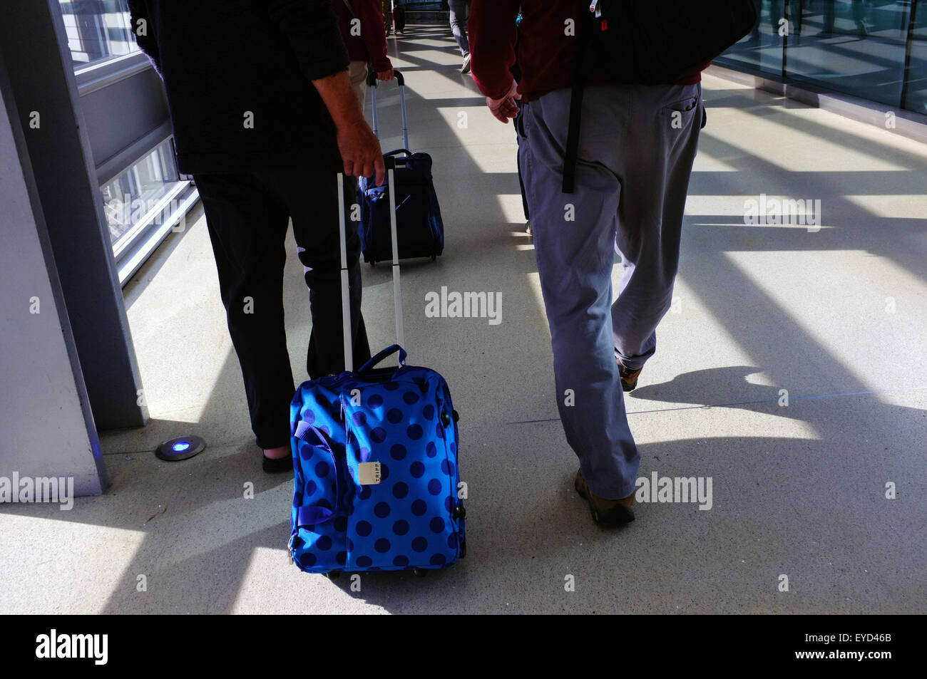 Passengers pulling their bags behind them walk through Dublin Airport in Dublin. Stock Photo