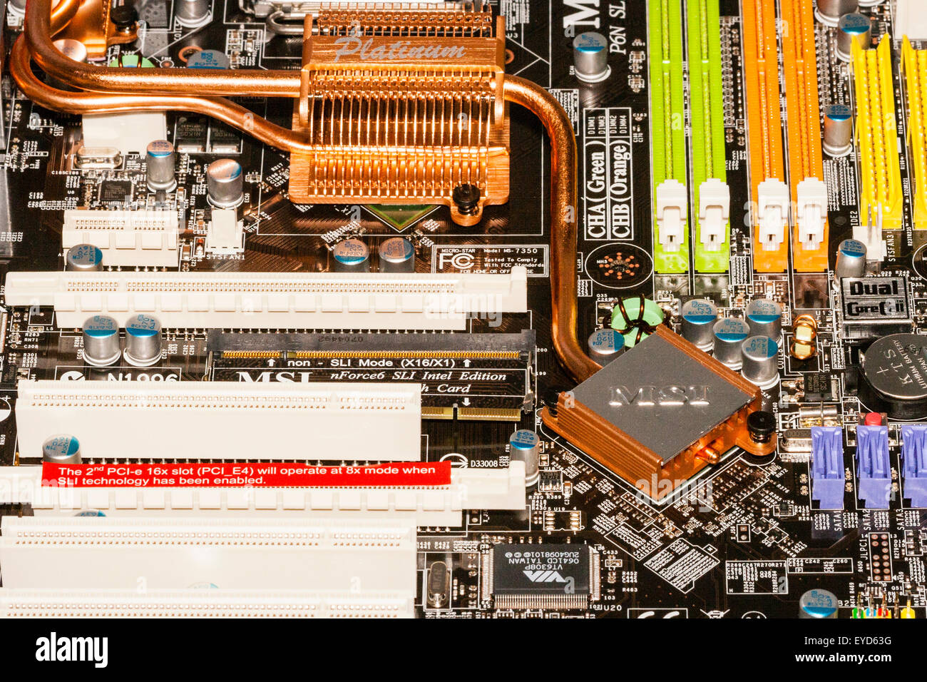 MSI Intel home computer motherboard with large copper coloured 'platinum' heatsink in the middle, and various other electronic components. Stock Photo