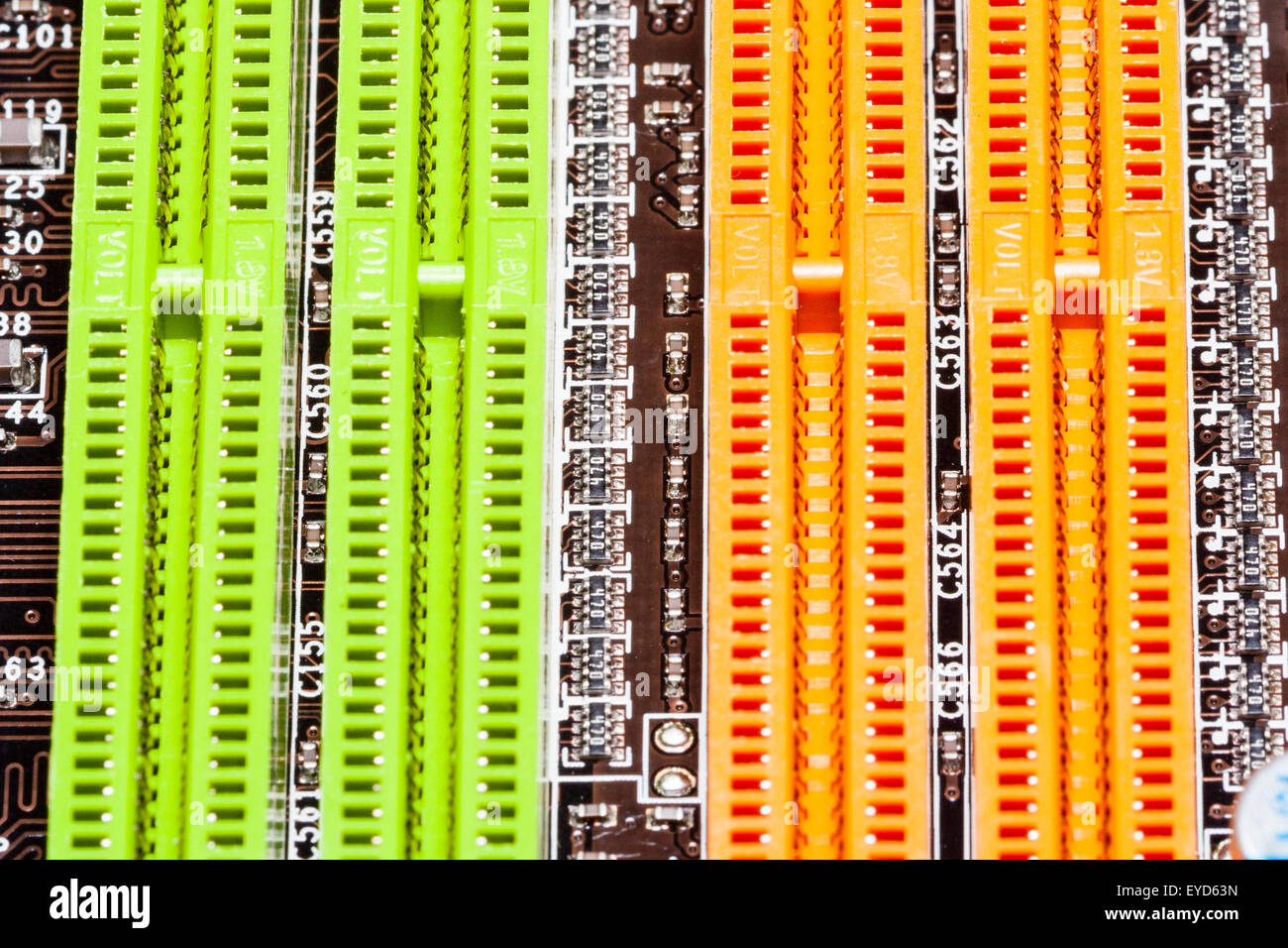 Home computer motherboard detail. Empty DIMM Ram memory slots on  motherboard, colour coded orange and green. Stock Photo