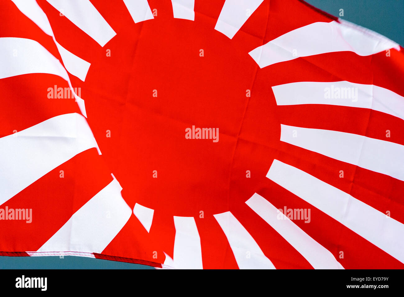 Japanese rising sun flag, Kyokujitsu-ki, Nisshōki or Hinomaru, used by the military in Second world war, dark storm clouds gathering in background. Stock Photo