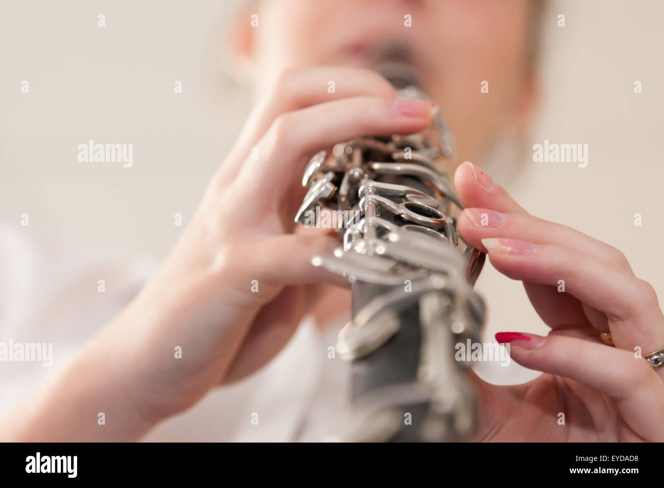 Girl playing a clarinet - close up and focussed on the fingers. Stock Photo