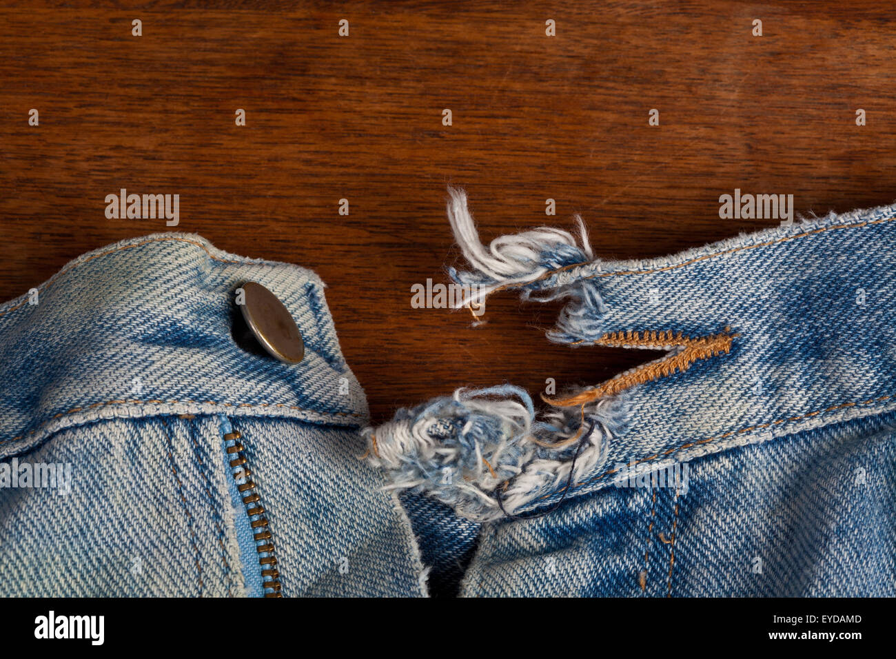 A ripped open button hole on well worn denim jeans Stock Photo - Alamy