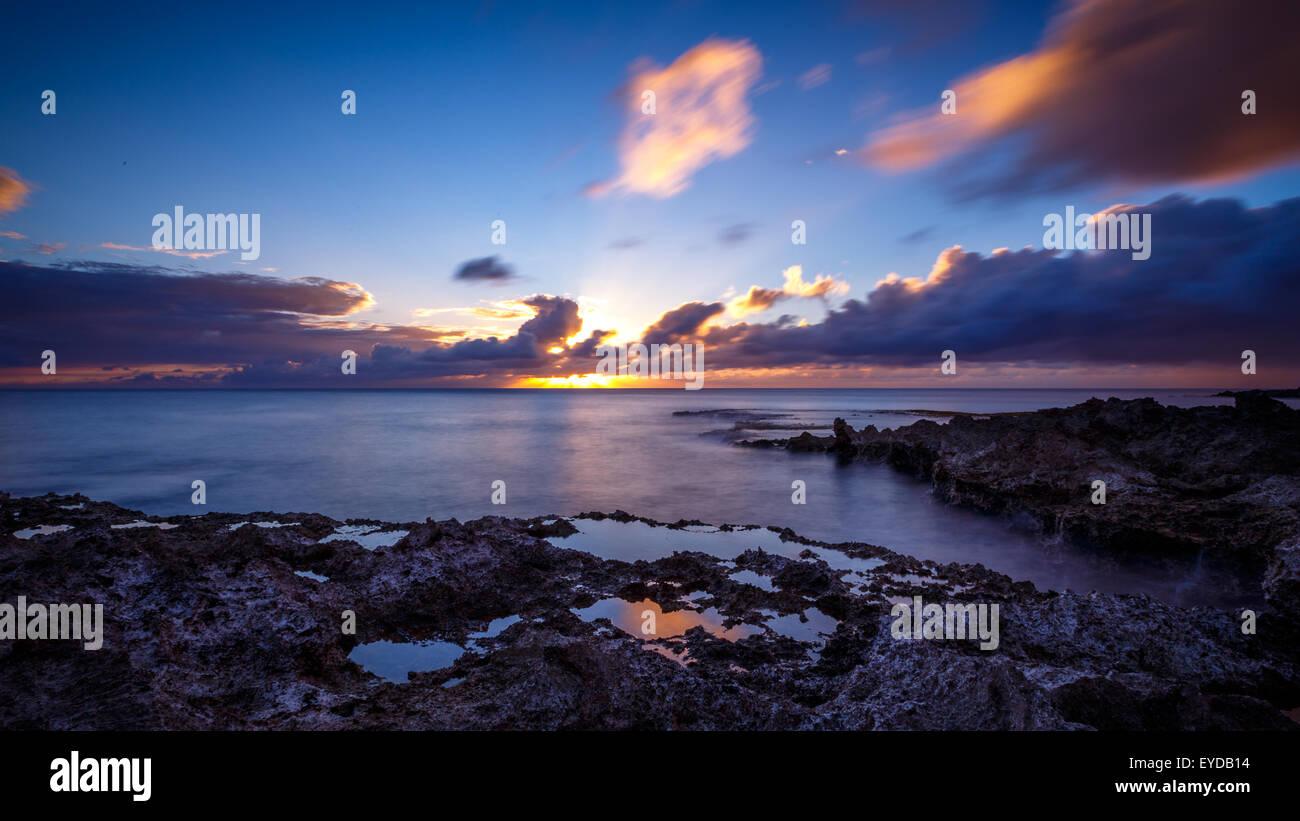 Sunset at Shark's Cove Beach with rocky shore Stock Photo