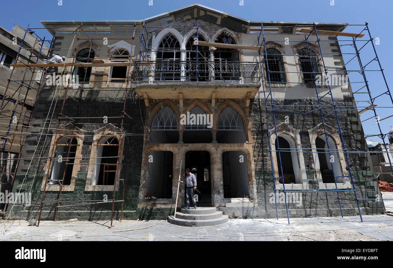 Homs, Syria. 27th July, 2015. Two Syrians work on a shattered school in the old city of Homs, central Syria, July 27, 2015. © Zhang Naijie/Xinhua/Alamy Live News Stock Photo