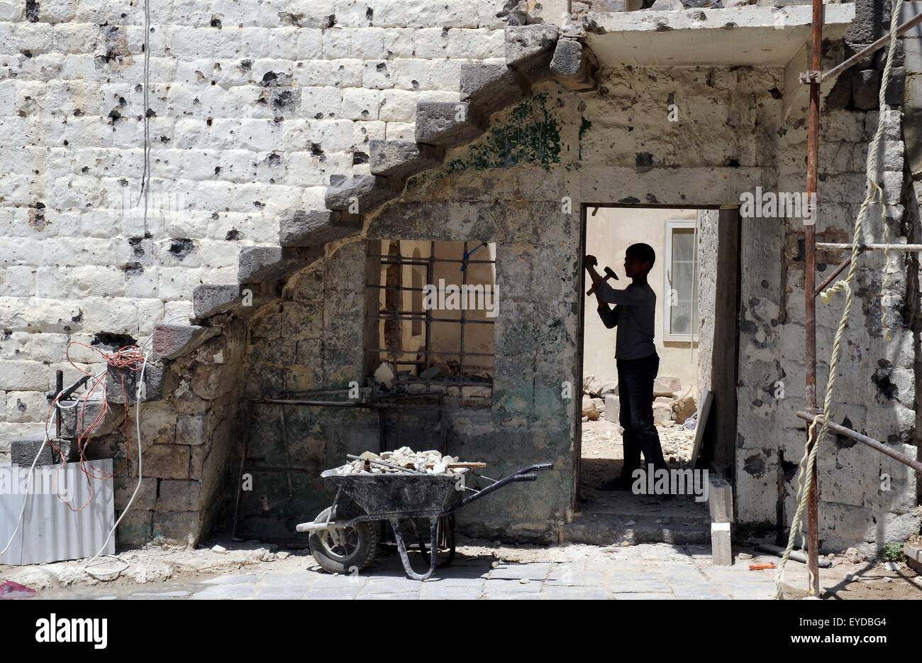 Homs, Syria. 27th July, 2015. A Syrian works on a shattered school in the old city of Homs, central Syria, July 27, 2015. © Zhang Naijie/Xinhua/Alamy Live News Stock Photo