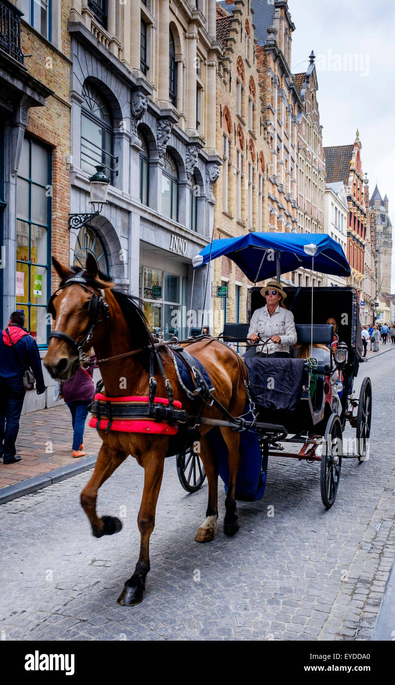 Tourists in a horse and trap in Steenstraat, Bruges, Belgium Stock Photo