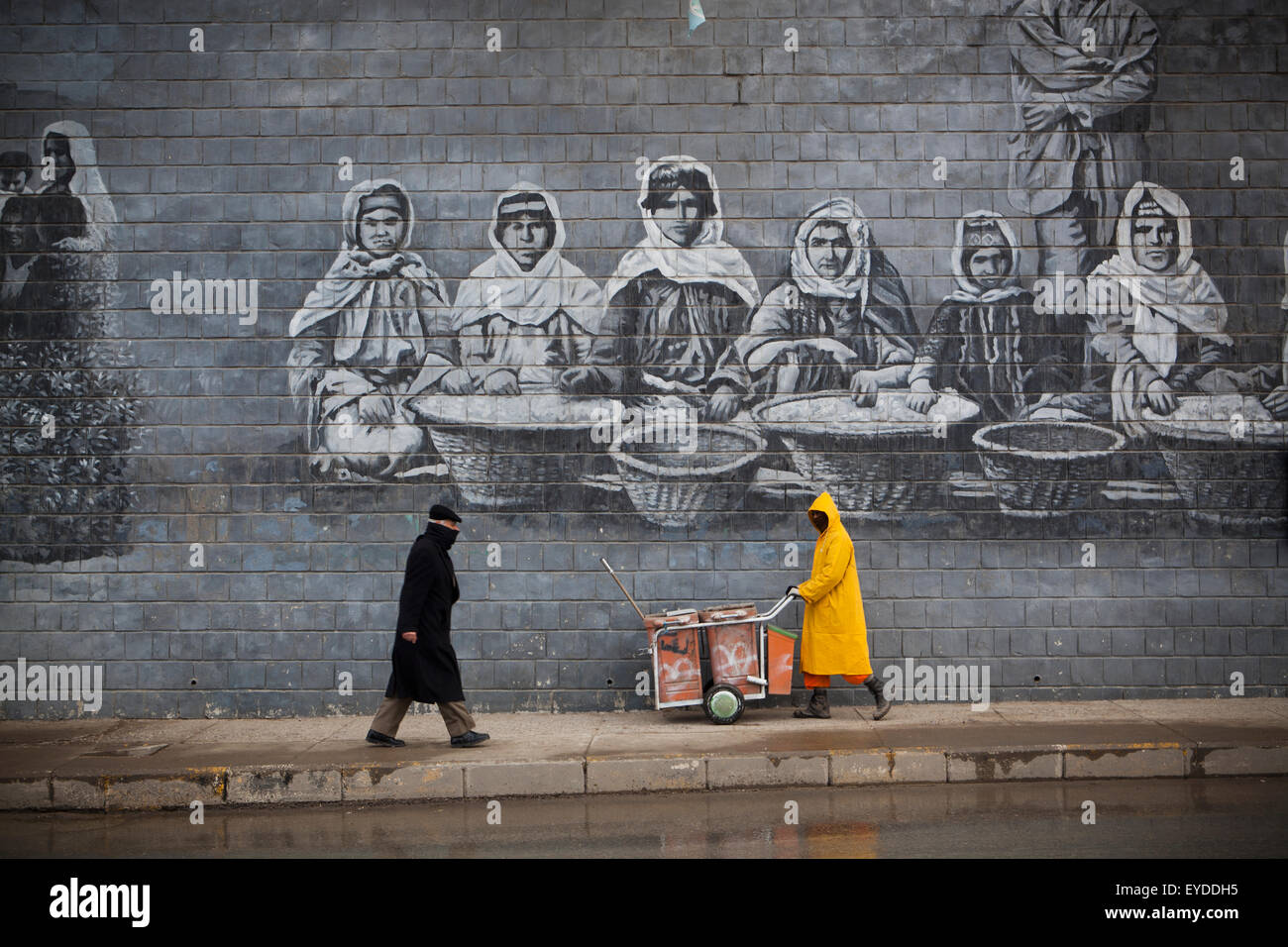 Street Cleaner In Front Of Mural Of Famous Kurdish People, Sulaymaniyah, Iraqi Kurdistan, Iraq Stock Photo