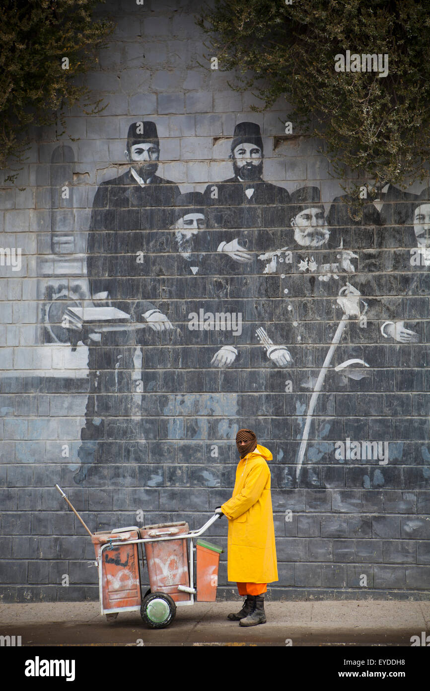 Street Cleaner In Front Of Mural Of Famous Kurdish People, Sulaymaniyah, Iraqi Kurdistan, Iraq Stock Photo