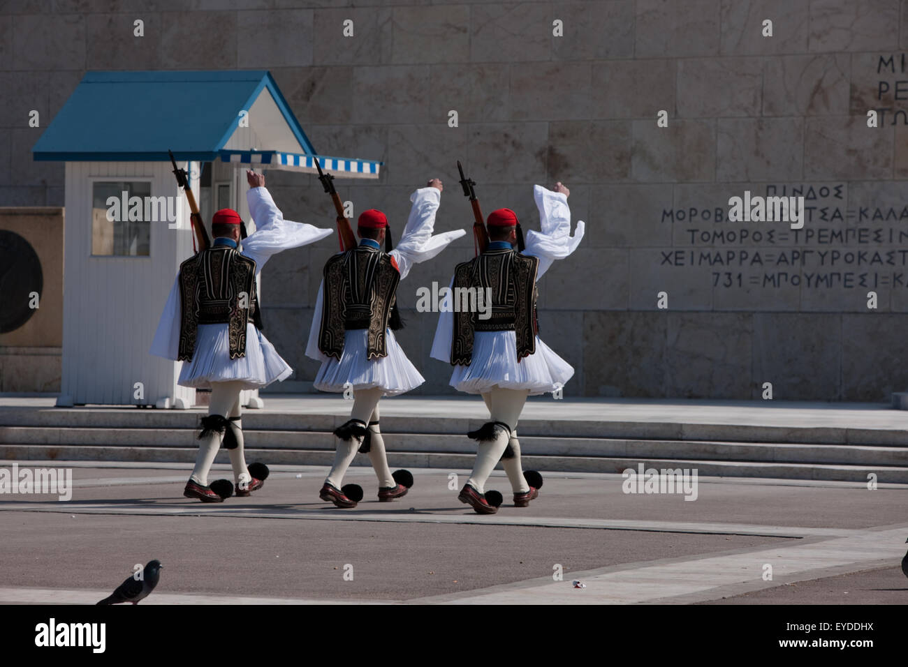 Greek guardsmen holding rifle guns march in front of the Unknown soldier monument in Syntagma, central Athens, Greece Stock Photo