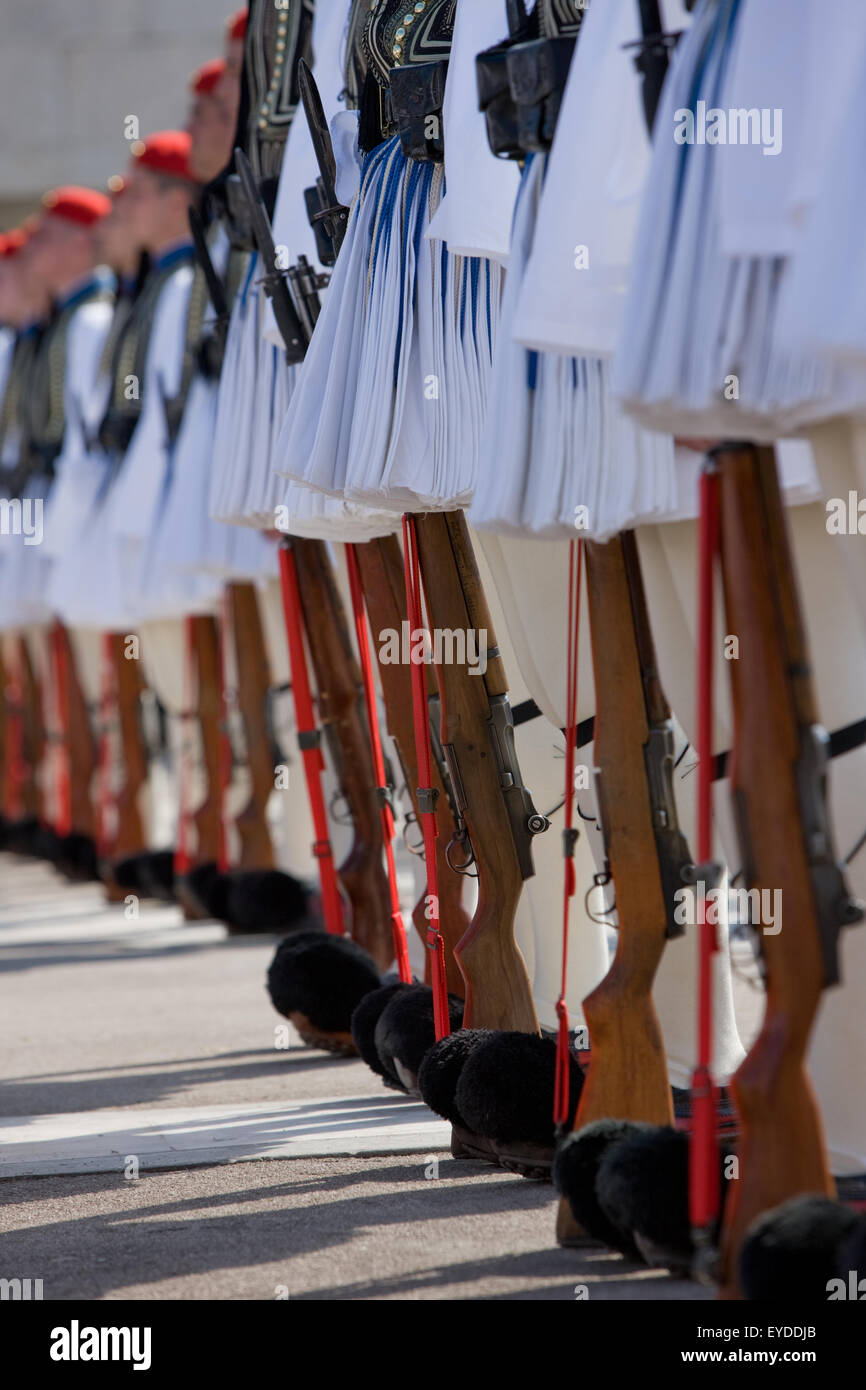 Vertical shot of lined-up Tsoliades or Evzones or Euzones waist down, legs and rifle guns, at Syntagma square. Athens, Greece Stock Photo