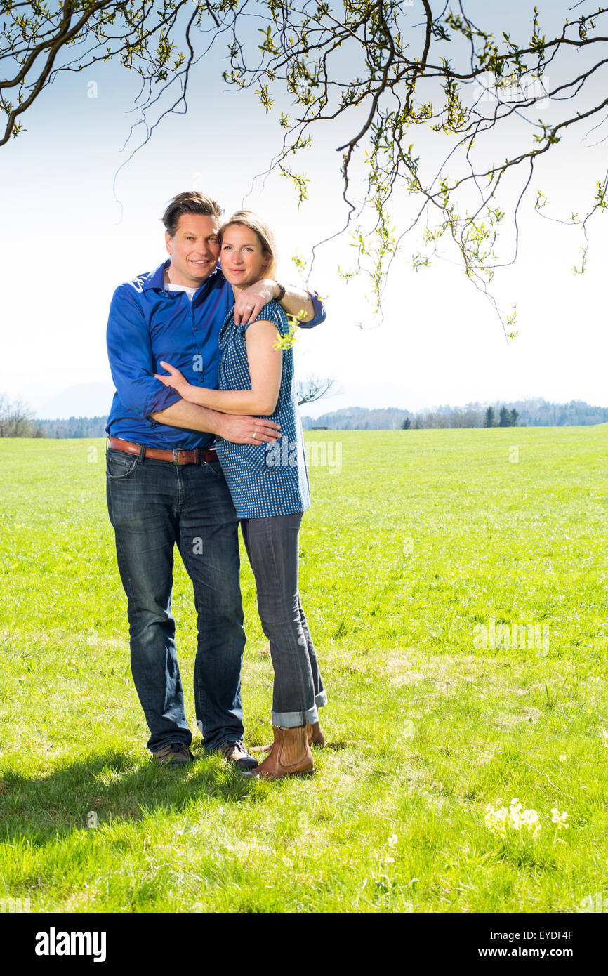 Happy couple embracing in meadow Stock Photo
