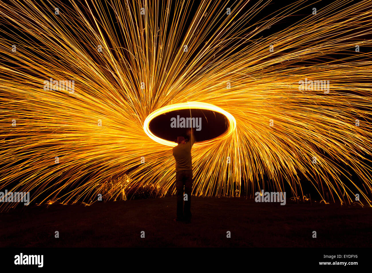 Man Spinning Ball Of Burning Steel Wool At Night, Petersfield, Hampshire, Uk Stock Photo