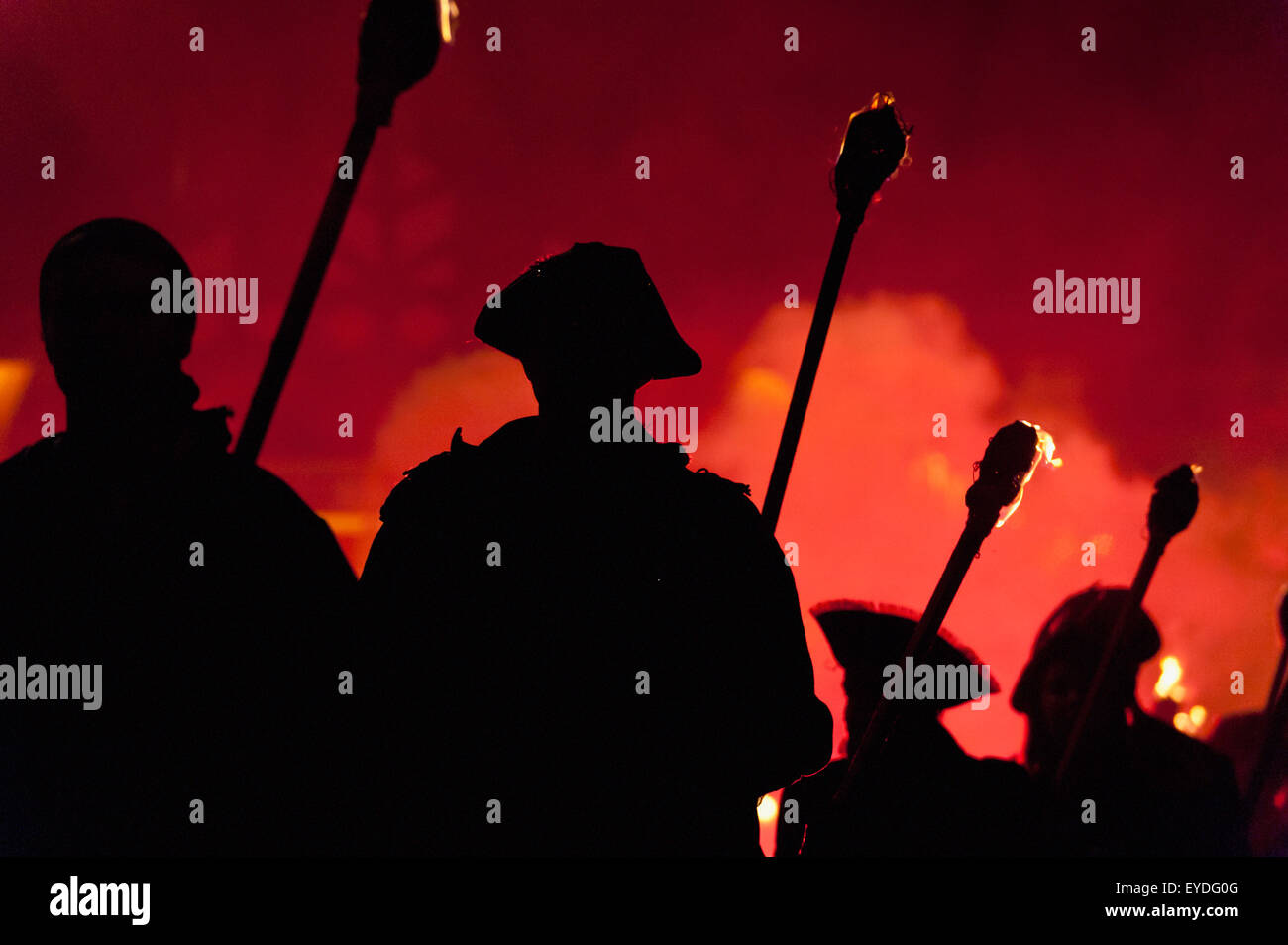 Silhouettes Of Pirates With Burning Torches Lit By Red Flare Walking Through Lewes On Bonfire Night, East Sussex, Uk Stock Photo