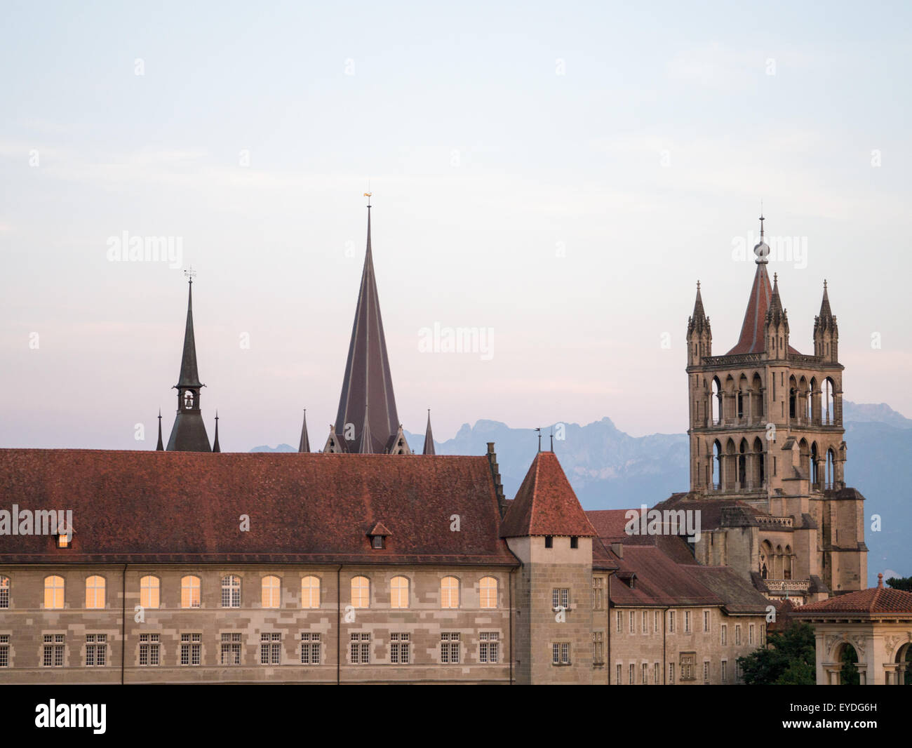 Lausanne cathedral in the evening light with mountains in the background Stock Photo