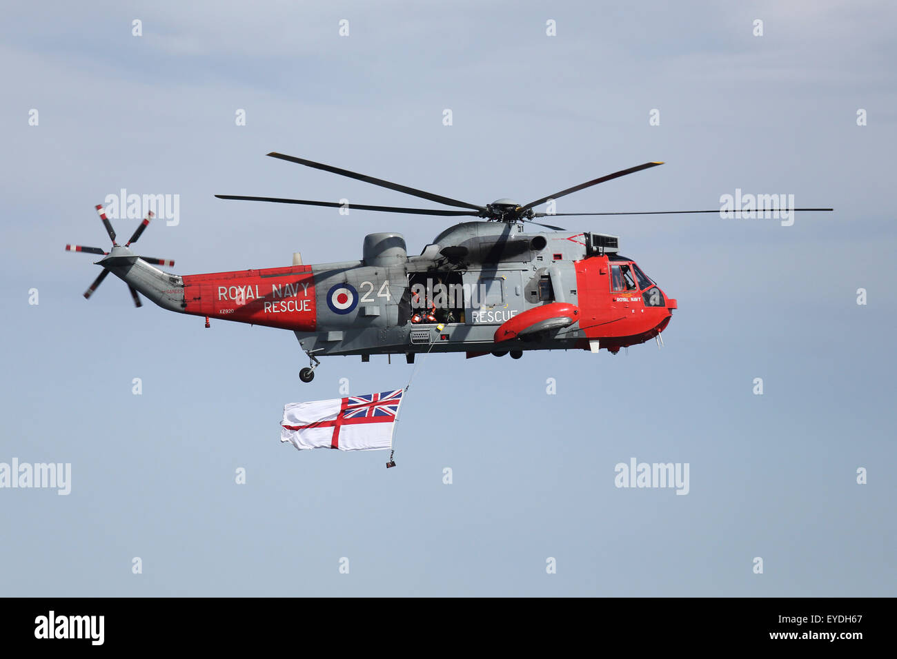 A Royal Navy Sea King HU5 helicopter performs at Sunderland International Airshow, England. The Sea King displays a white ensign Stock Photo