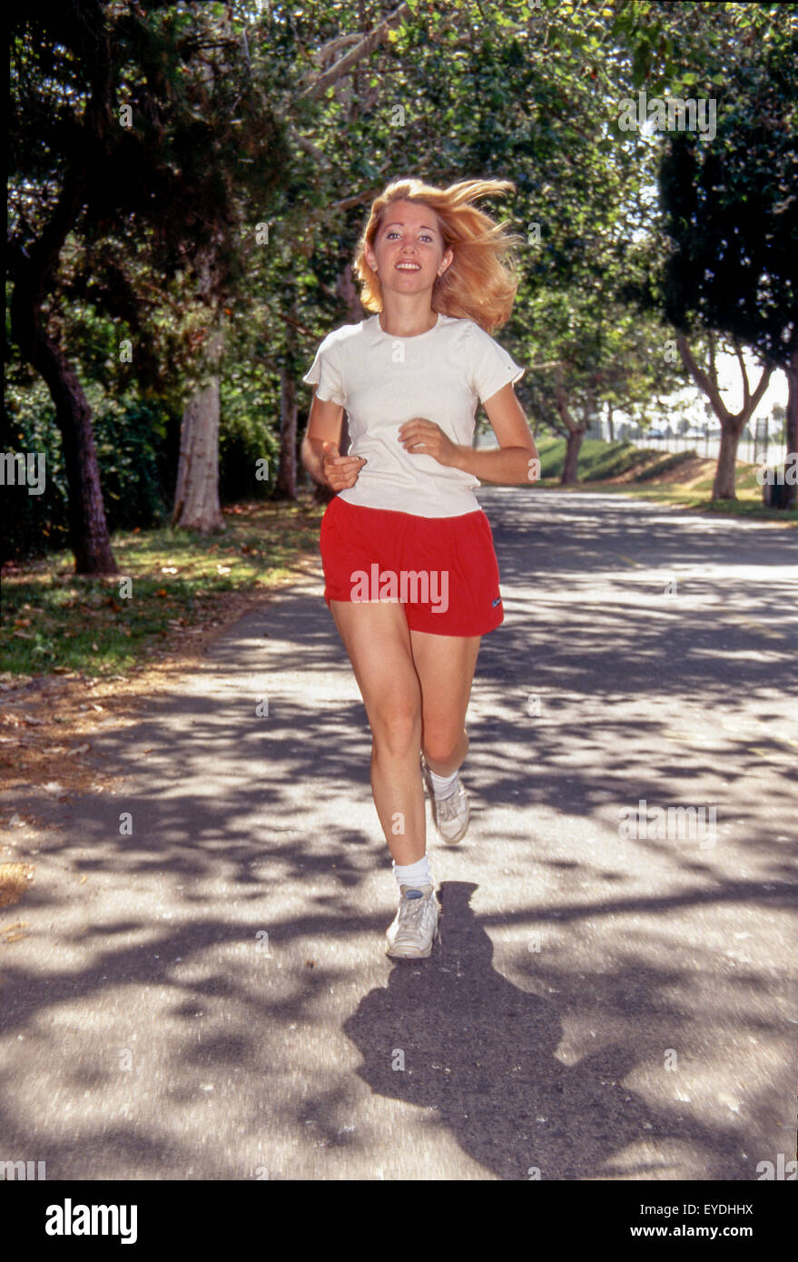 A blonde 20-year-old woman has an afternoon run in a Long Beach, CA, park. Stock Photo
