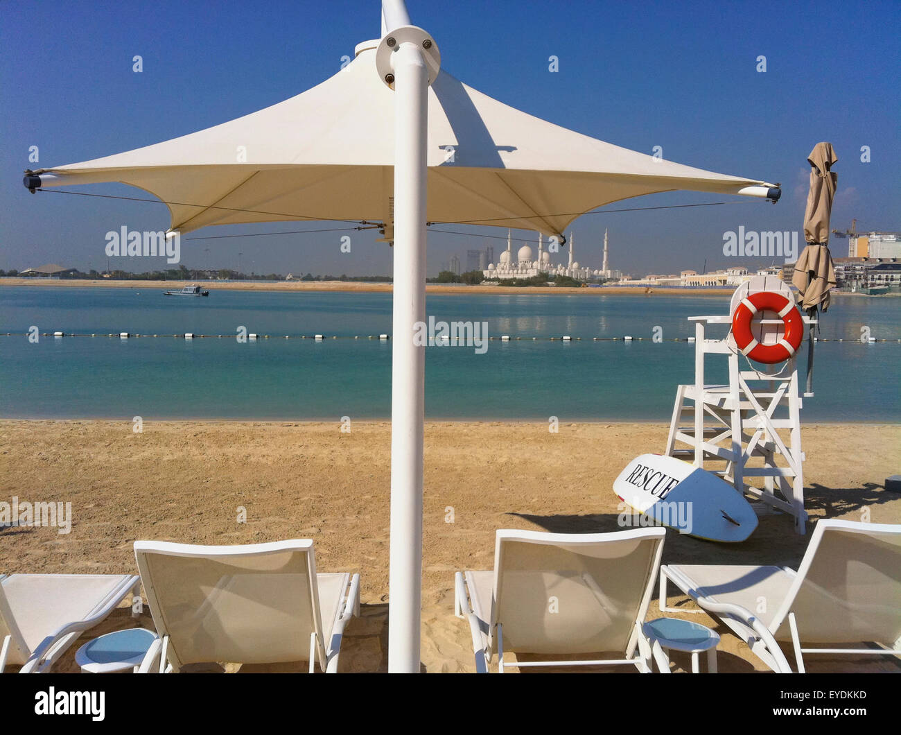 United Arab Emirates, Abu Dahbi, Shangri-la Hotel, Shaikh Zayed Bin Sultan Al Nahyan Mosque in background, Parasol on beach Stock Photo