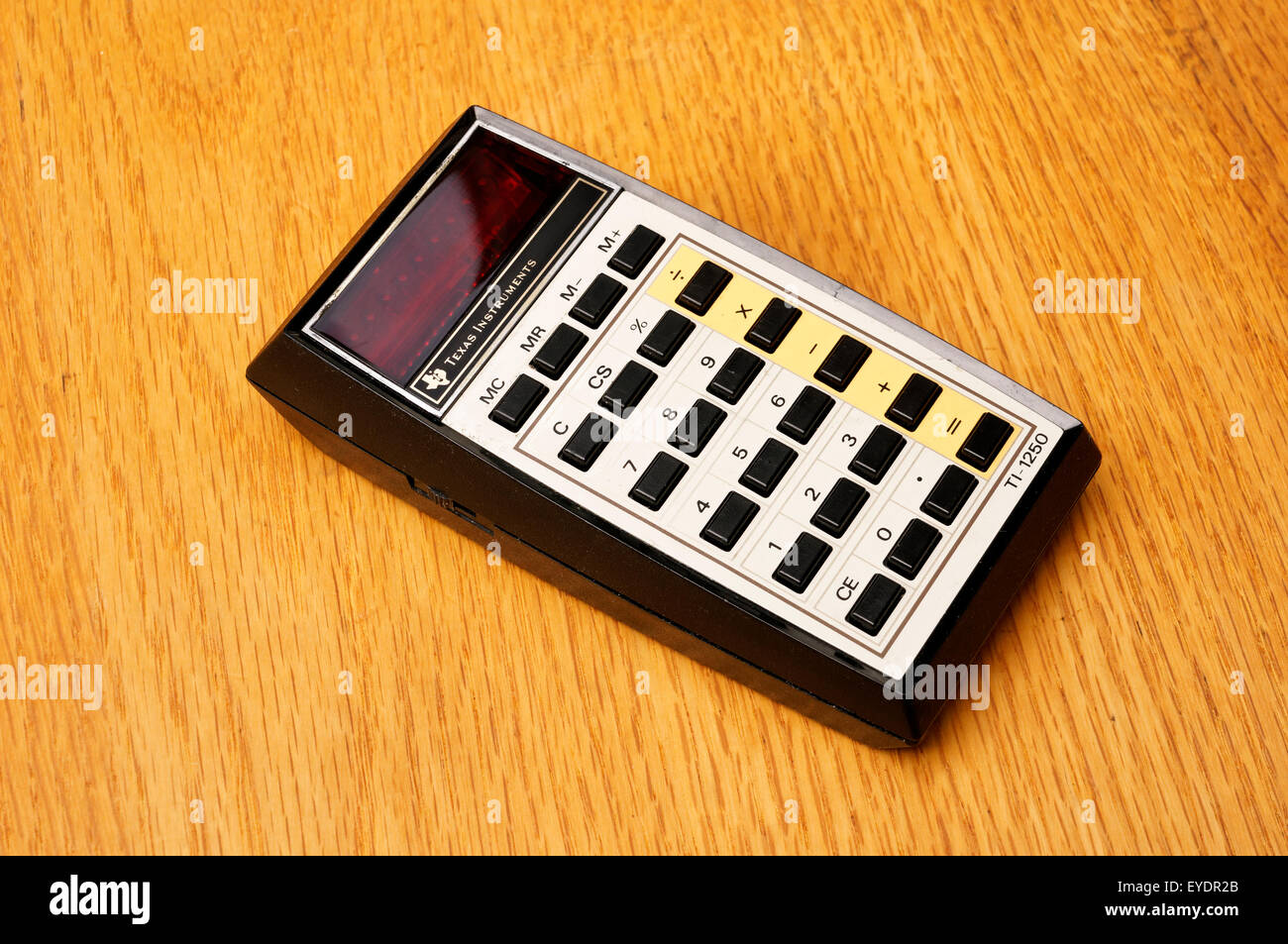 Vintage Texas Instruments TI-1250 basic electronic math calculator introduced in 1975 on an old wooden desk Stock Photo