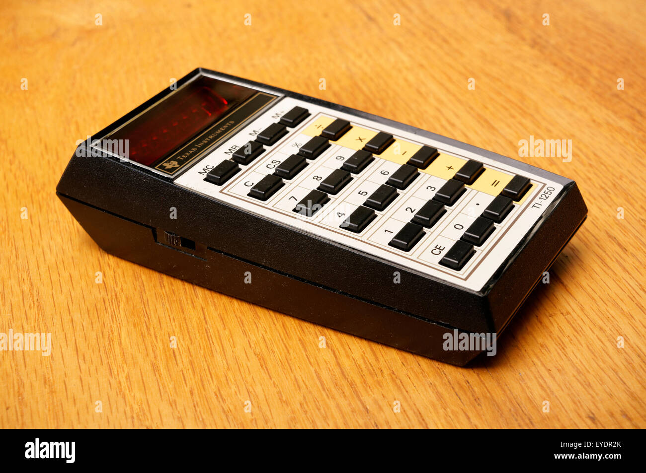 Vintage Texas Instruments TI-1250 basic electronic math calculator introduced in 1975 on an old wooden desk Stock Photo