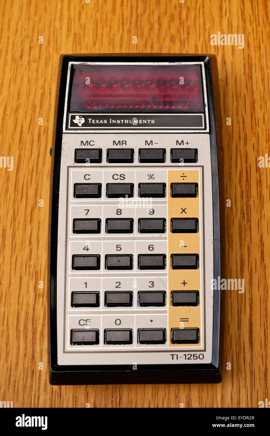 Vintage Texas Instruments TI-1250 basic electronic math calculator introduced in 1975 on an old wooden desk Stock Photo
