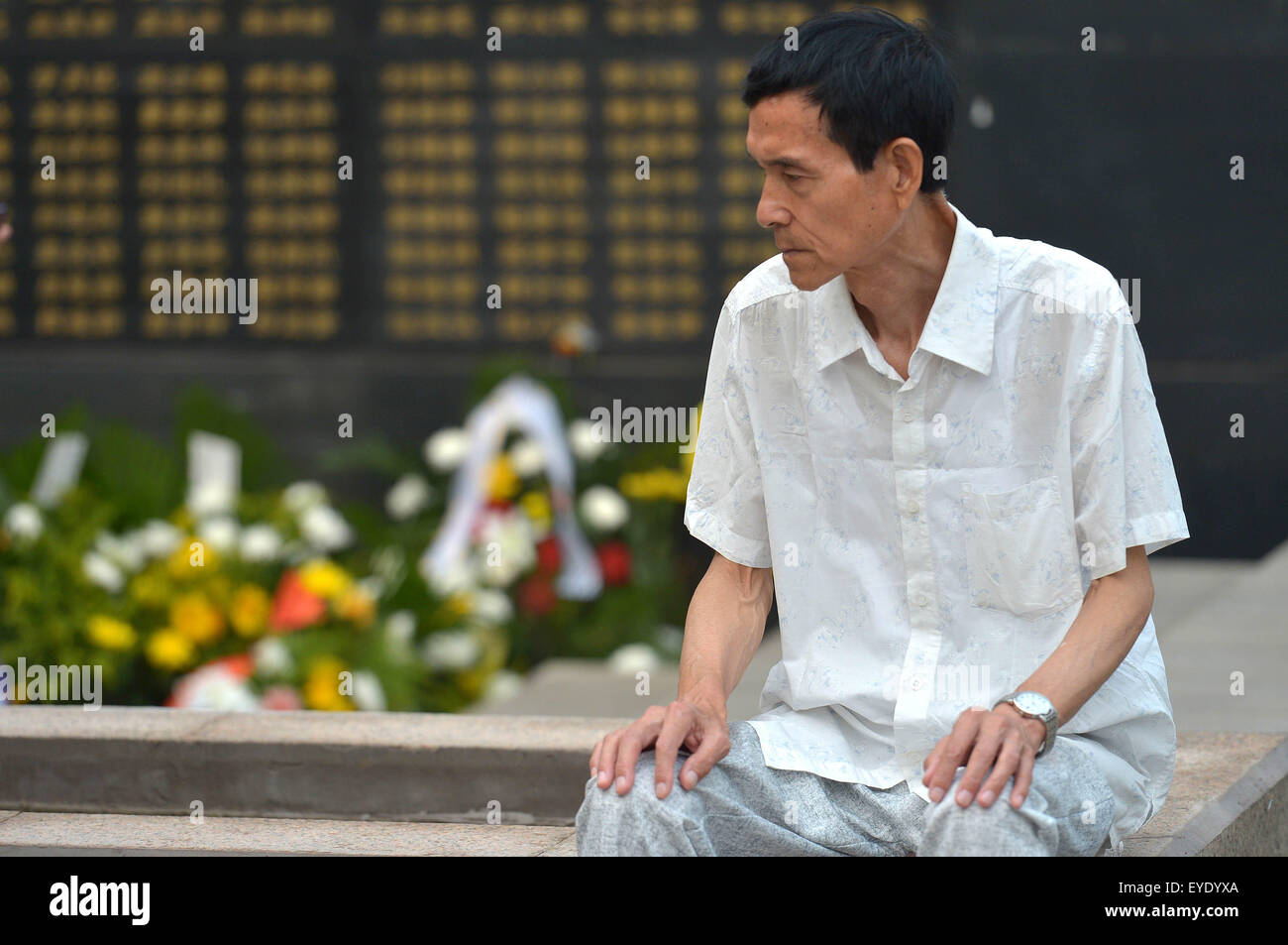 Tangshan, China's Hebei Province. 28th July, 2015. A man mourns for relatives dead in the 1976 Tangshan earthquake in front of the memorial wall in Tangshan, north China's Hebei Province, July 28, 2015. Local residents came to the memorial park on Tuesday to commemorate the 39th anniversary of the Tangshan earthquake. Credit:  Zheng Yong/Xinhua/Alamy Live News Stock Photo