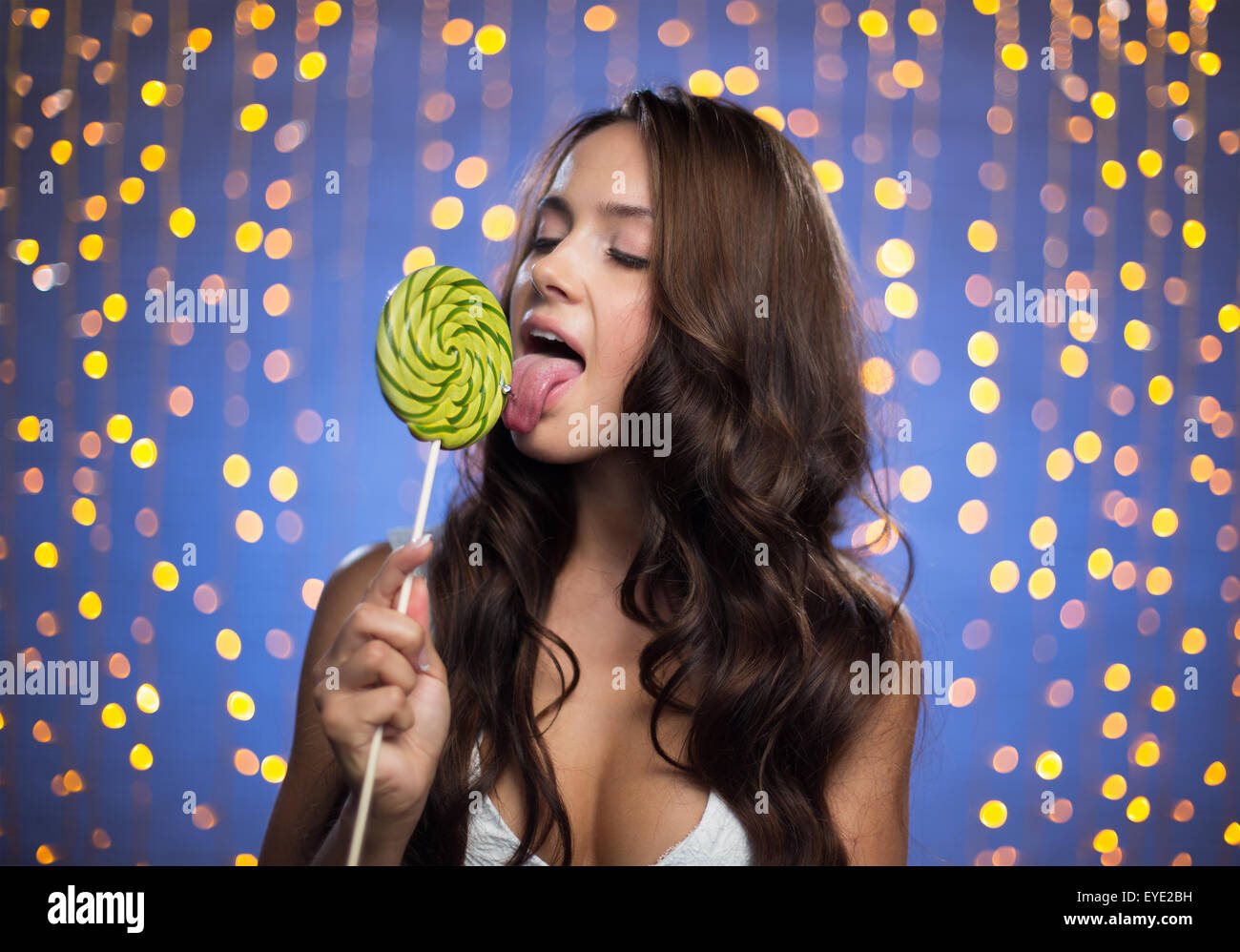 Pretty girl with long hair licking lollipop Stock Photo