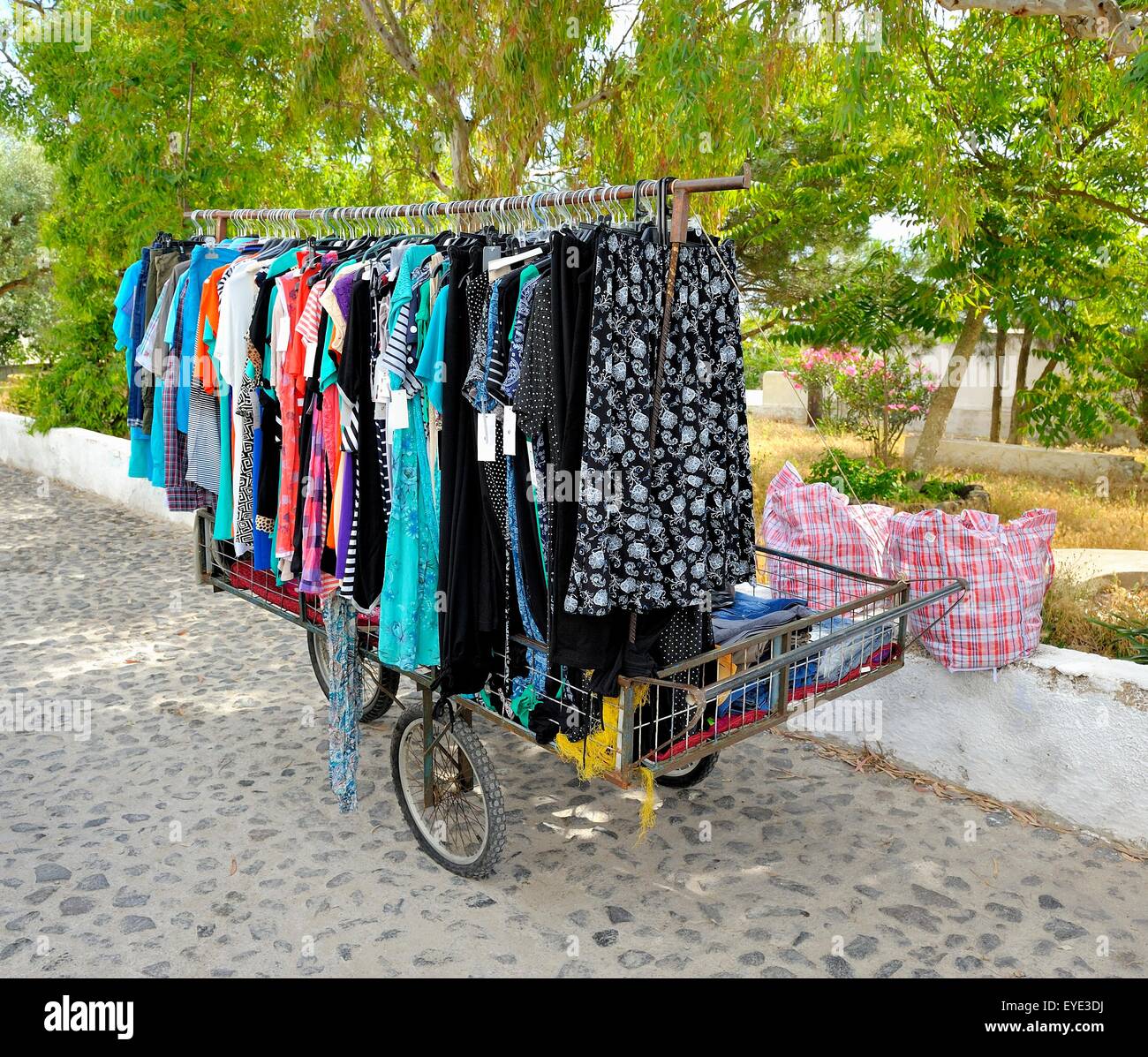 A local woman with a mobile market stall selling children's clothing